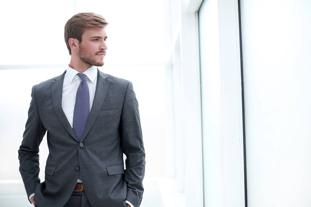 close up. focused young businessman standing in office - Foto, afbeelding