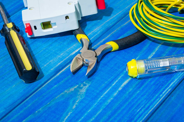 Mavi ahşap tahtalarda elektrikçi için yedek parça ve aletler - Fotoğraf, Görsel