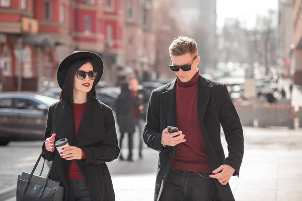 man and a woman in black go and look at the phone - Foto, Imagem
