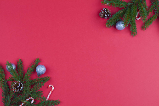 Weihnachten Hintergrund mit Tannenbaum Brunch, Tannenzapfen und Silberkugeln auf rotem Hintergrund. - Foto, Bild
