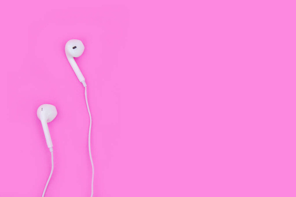 Smartphone con auriculares sobre fondo rosa con espacio de copia y
 - Foto, Imagen