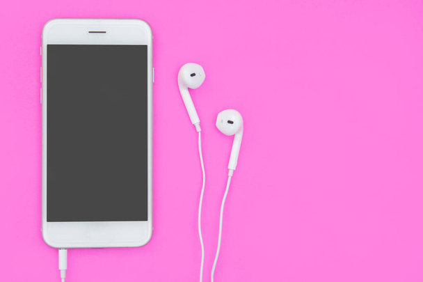 Smartphone with Earphones on pink background with copy space and - Photo, Image