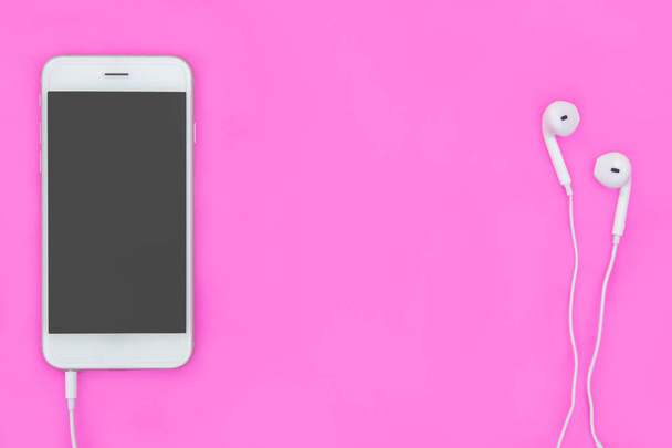 Смартфон з навушниками на рожевому фоні з місцем для тексту та
 - Фото, зображення