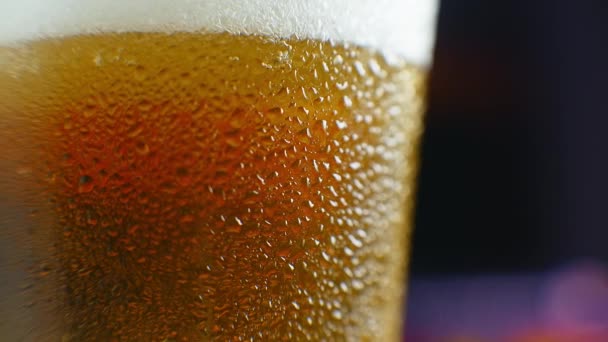 Close-up slow motion: birra fredda in un bicchiere grandi gocce e bollicine nella birra
. - Filmati, video