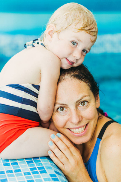 Swimming pool. Mom teaches a young child to swim in the pool. - Foto, Bild