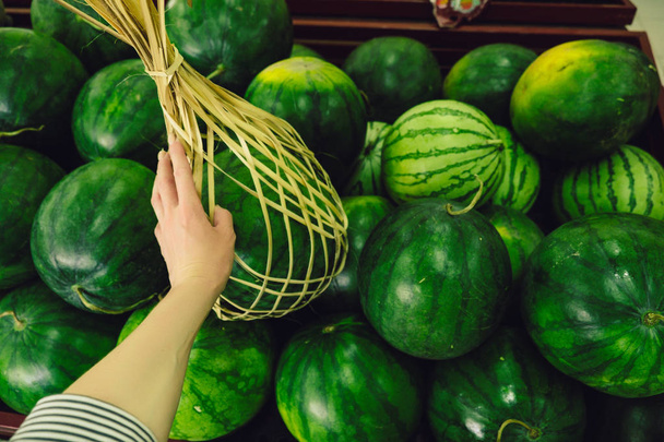 A tourist at a market chooses watermelon at a local market in Ba - Фото, изображение