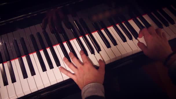 Pianista maschile che esegue una canzone al pianoforte con luce bassa e vista dall'alto
. - Filmati, video