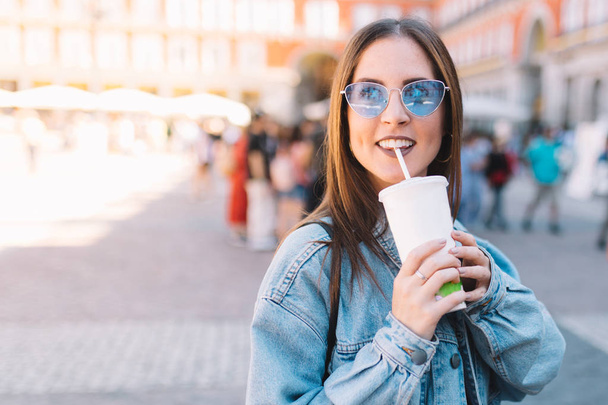 Happy urban woman with blue sunglasses enjoying her morning drin - Foto, Imagem