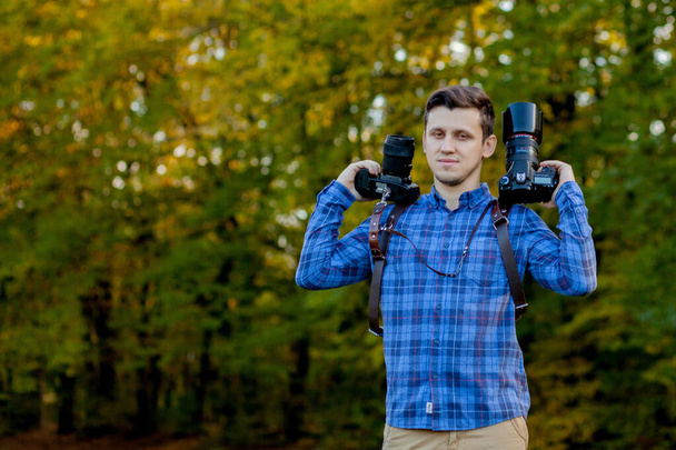 Professional photographer in action with two cameras on a shoulder straps - Fotó, kép