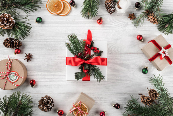 創造的なフレーム クリスマスもみのマツ円錐形、内装は赤と白の木製の背景の枝。クリスマスと新年のテーマです。フラット横たわっていた、トップ ビュー - 写真・画像