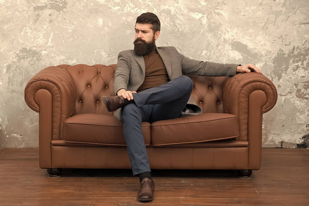 Elegant and confident. Man of fashion. Fashion model relaxing on sofa. Bearded man enjoying casual fashion style. Fashionable businessman. Business and fashion - Photo, image
