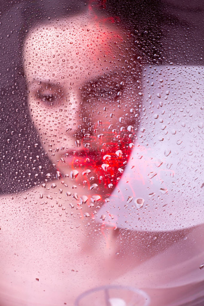 beautiful young brunette girl portrait under a glass of water - Foto, Imagem