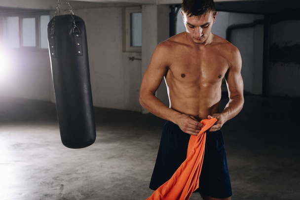 Fiatal bokszoló felkészülni az edzésre, miközben ruhát cserél - Fotó, kép