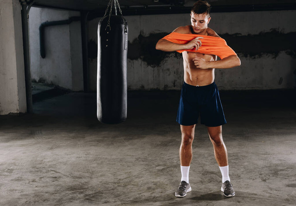 Jeune boxeur se préparer pour l'entraînement tout en changeant de vêtements
 - Photo, image