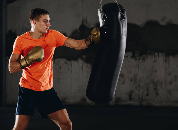 Молодой человек в боксерских перчатках. Боксёр готов к бою. Бокс, тренировки, мышцы, сила, сила - понятие силового тренинга - Фото, изображение