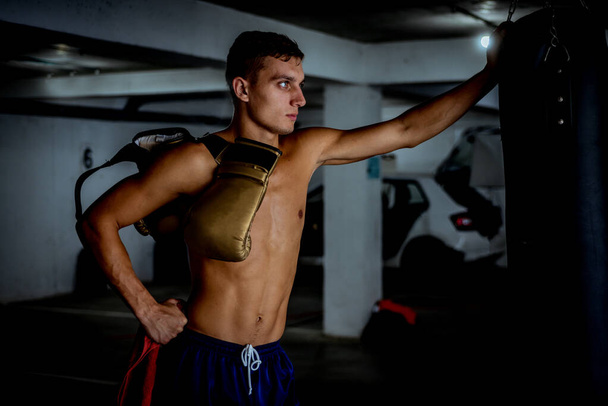 Profesionální mladý boxer po boxerském tréninku v garáži - Fotografie, Obrázek