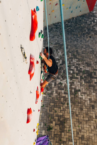 Uomo sportivo si arrampica sulla parete di roccia artificiale
 - Foto, immagini