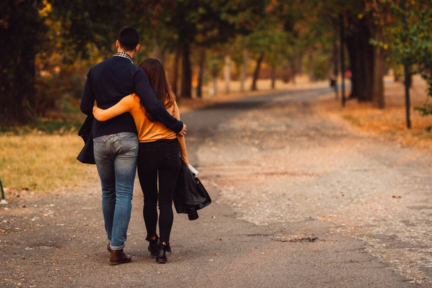 Pari kävelee puistossa auringonlaskun aikaan tunne rakastettu ja onnellinen
. - Valokuva, kuva