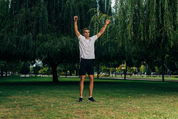 Blanke man oefening en strek spieren in een park - Foto, afbeelding