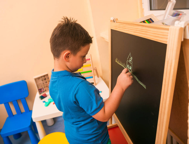 Kid writing on chalkboard before medical examination - Фото, зображення