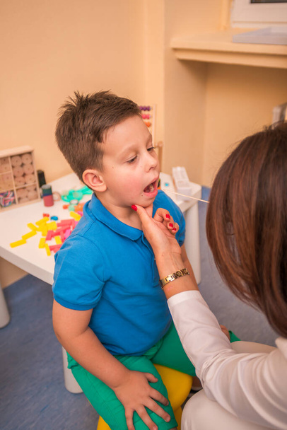 Žena Pediatr šek je hrdlo a ústa mladého roztomilého chlapce. - Fotografie, Obrázek