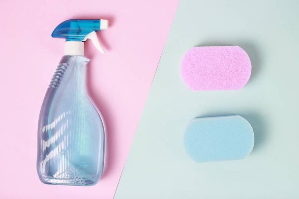 Spray de ventana, esponjas sobre fondo azul y rosa vista superior, concepto de limpieza de primavera
 - Foto, Imagen