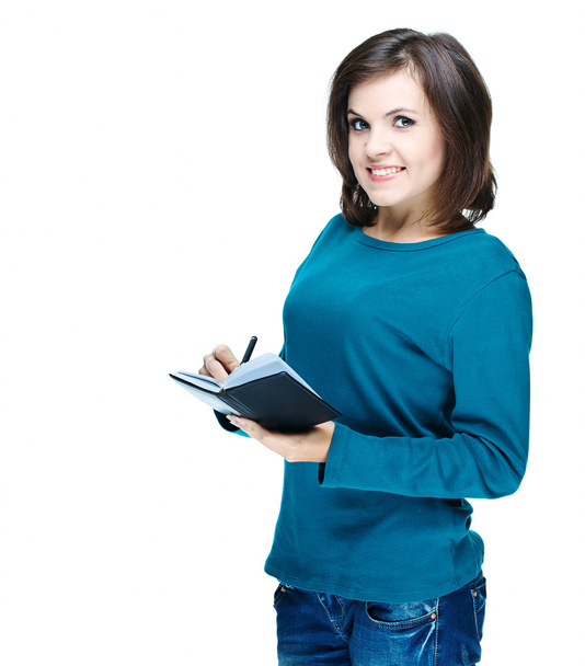 Attractive smiling girl in a blue shirt holding a notebook and w - Φωτογραφία, εικόνα