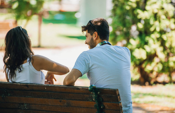 Ένα ζευγάρι νέων ανθρώπων συναντήθηκε στο πάρκο. Λάτρεις της κάθονται σε μια  - Φωτογραφία, εικόνα