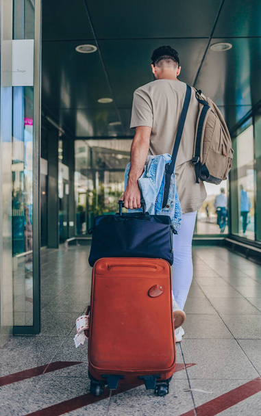 Mann trägt Gepäck am Flughafen-Terminal - Foto, Bild