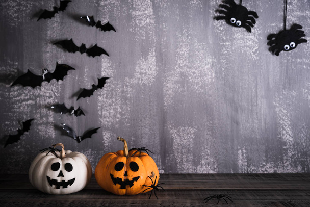 Orange ghost pumpkins with witch hat on gray wooden board background with bat. halloween concept. - Foto, afbeelding