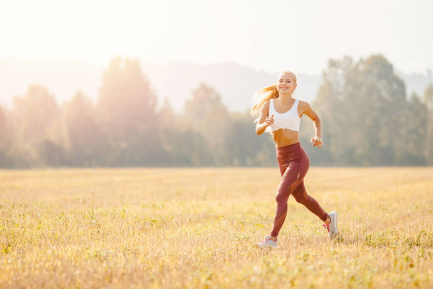 Young blond fitness woman runner athlete running park Sunrise - Foto, Imagem