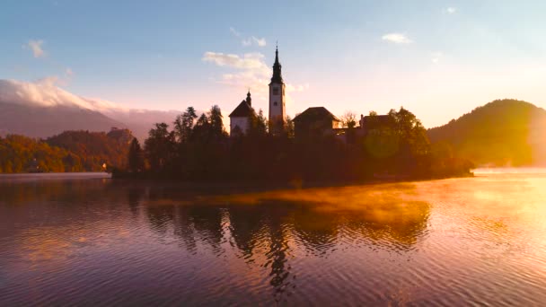 Lake Bled syksyllä, Slovenia St. Marys kirkko Neitsyt pienellä saarella vedessä ja kaunis auringonlasku
 - Materiaali, video