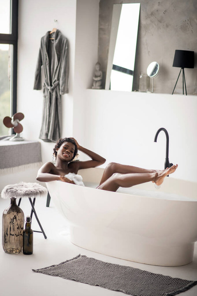 Woman chilling in bath in spacious bathroom with modern interior - Fotoğraf, Görsel