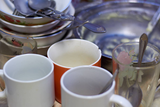 Dirty dishes on the table, mugs, plates, spoons. Kitchen, cook. - Foto, afbeelding
