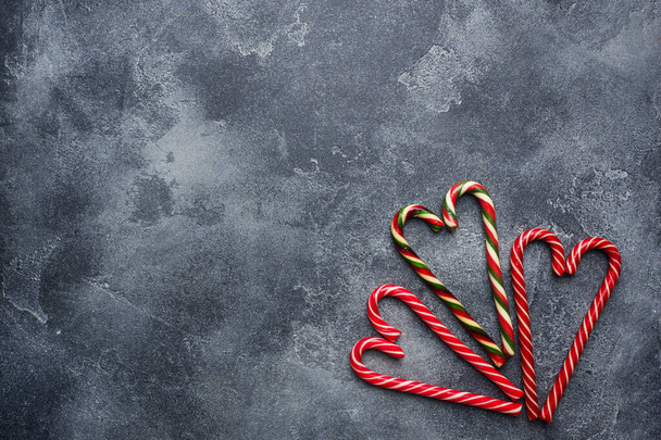 Christmas candy cane heart shaped on dark grey background with copy space. - Fotoğraf, Görsel