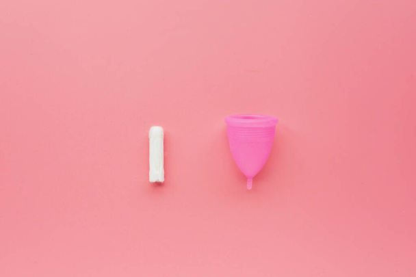 Menstrual cup and tampon on pink background. Alternative feminine hygiene product during the period. Women health concept. Copy space. Eco friendly concept, zero waste product. Flat lay, mockup, templ - Фото, изображение