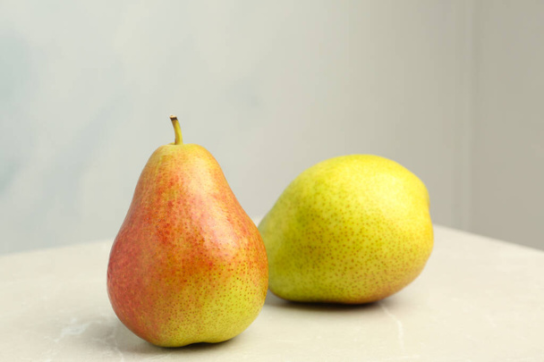 Ripe juicy pears on stone table against light background - Foto, Imagen