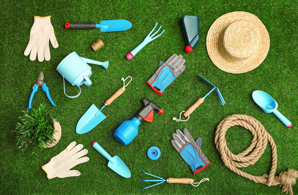 Set of gardening tools on green grass, flat lay - Foto, afbeelding