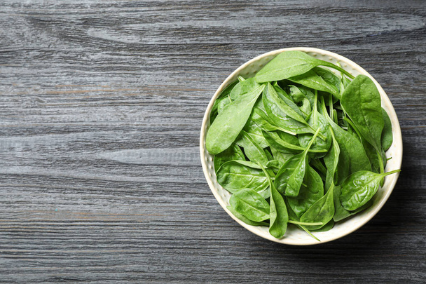 Fresh green healthy spinach on dark wooden table, top view. Space for text - Photo, Image