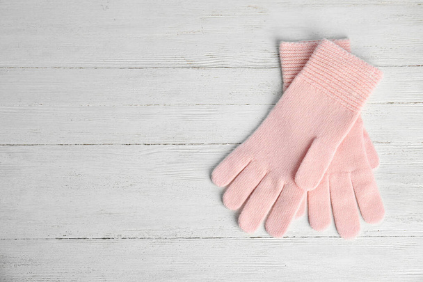 Stylish pink gloves on white wooden background, top view with space for text. Autumn clothes - Фото, изображение