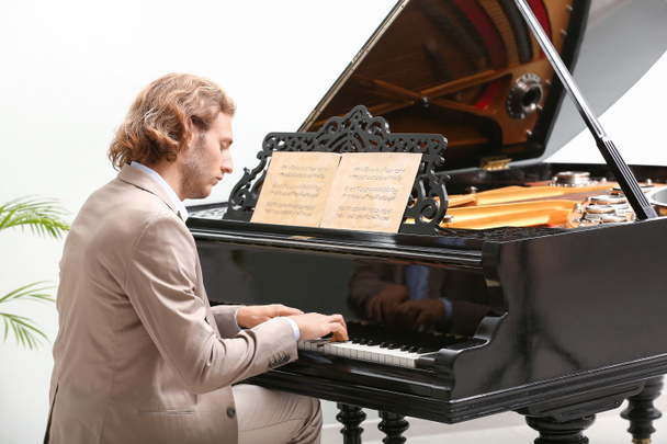 Чоловік грає на піаніно вдома
 - Фото, зображення