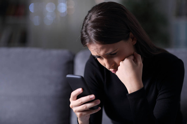 Worried girl reading phone message in the night - Zdjęcie, obraz