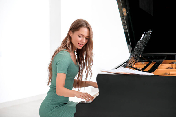 コンサートでグランドピアノを演奏する若い女性 - 写真・画像