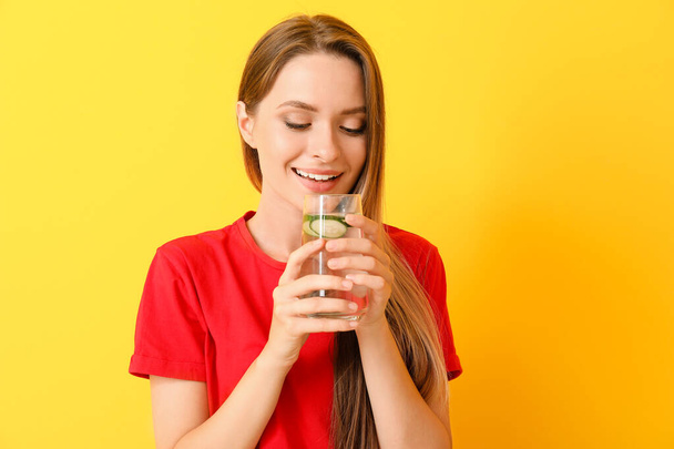 Γυναίκα πίνει νερό με έγχυση στο φόντο του χρώματος. Έννοια διατροφής - Φωτογραφία, εικόνα