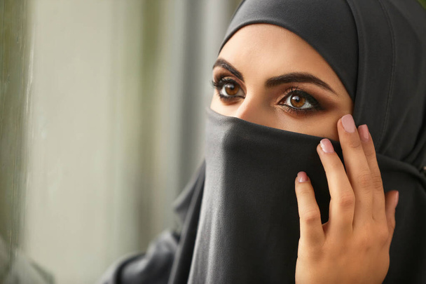 Portret van een mooie moslimvrouw bij het raam - Foto, afbeelding