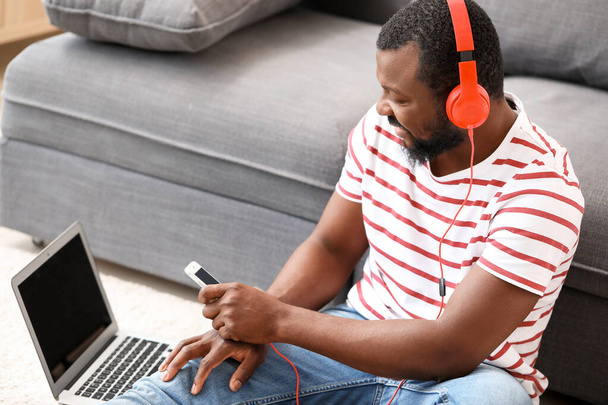 Knappe Afro-Amerikaanse man luisteren naar muziek thuis - Foto, afbeelding