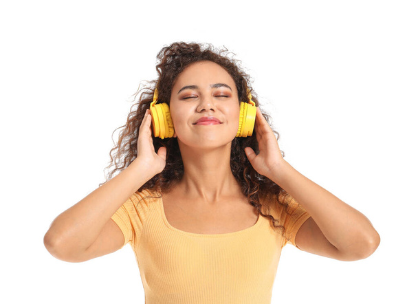 Прекрасна афро-американська жінка, яка слухає музику на білому фоні - Фото, зображення