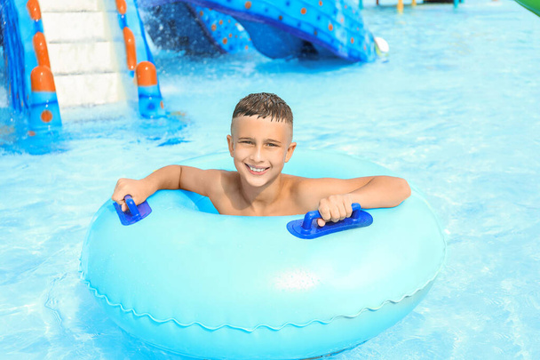 Leuke jongen op zwemring in aquapark - Foto, afbeelding
