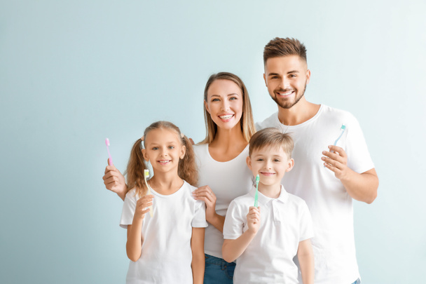 Portrait of family with toothbrushes on light background - Foto, imagen