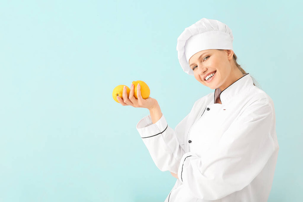 Beautiful female chef with lemons on light background - Foto, Imagem